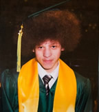 Christopher Kalonji is pictured proudly sporting his high school graduation cap high on his afro.